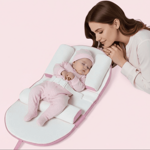 Woman with a baby on a white and pink baby lounger baby sleeping