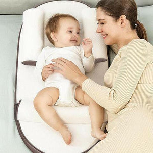 Mom and her baby smiling on SleepWell™ infant support bed – safe baby lounger alternative