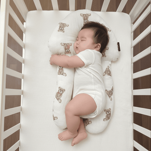 Baby sleeping on a white crib mattress with teddy bear pattern