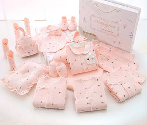 Collection of pink baby clothes and accessories on a white background