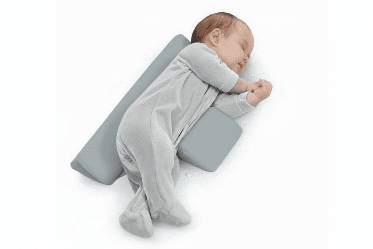 Baby sleeping on a gray pillow with a soft blanket