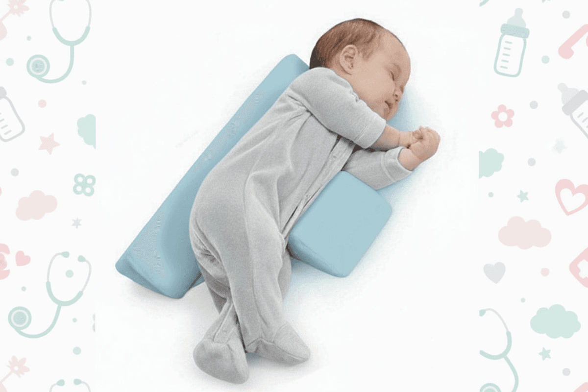 Baby sleeping on a blue pillow with a patterned background
