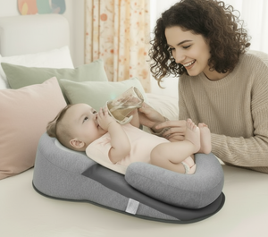 Woman feeding a baby with a bottle on a gray baby seat in a cozy room.