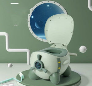 A green and gray SkySit Potty Chair designed for toddlers, featuring a space-themed lid and a fan-shaped backrest, placed against a stylized bathroom backdrop with decorative elements.