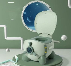A green and gray SkySit Potty Chair designed for toddlers, featuring a space-themed lid and a fan-shaped backrest, placed against a stylized bathroom backdrop with decorative elements.