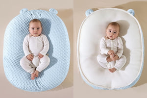 Baby lying on a blue and white Doudou Bear double-sided cushion with text indicating different fabric types.