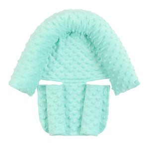 A newborn baby sleeping in a car seat, equipped with a white and blue sleeping pillow with a soft plush toy attached to the baby's stroller.