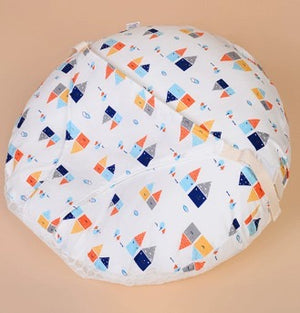 Round baby play mat with colorful geometric pattern on a beige background