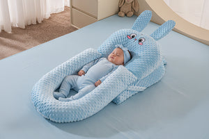 A baby lying in a white U-shaped inclined sleeper pillow with a soft texture, designed for anti-reflux and secure sleeping.