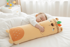 Child sleeping on a plush toy shaped like a cartoon character in a bedroom setting.