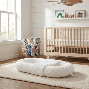 White baby wrap on a rug in a nursery with a crib and toys in the background