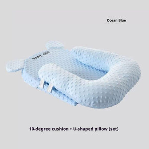 Baby bed with 10-degree cushion and U-shaped pillow in ocean blue color on a light gray background.