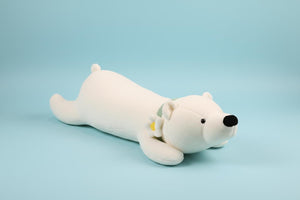 White plush toy dog lying on a textured surface with a blurred background