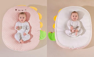 Baby nest with dinosaur design in pink and white on a beige background