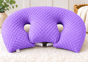 Purple U-shaped pillow on a white surface with a blurred background