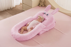 A baby lying in a white U-shaped inclined sleeper pillow with a soft texture, designed for anti-reflux and secure sleeping.