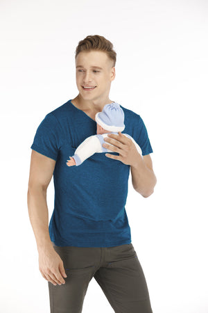 Man holding a baby in a blue outfit against a white background