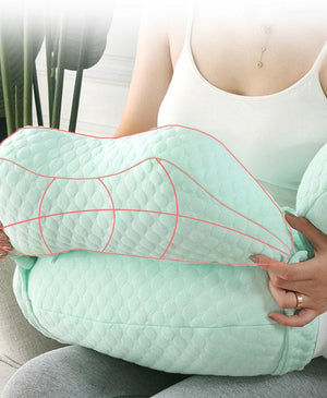 Person holding a green U-shaped pillow with red stitching details