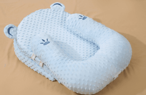 Blue baby pillow with paw print design on a beige background