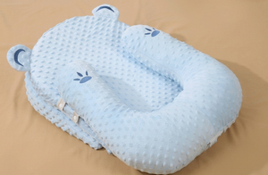 Blue baby pillow with paw print design on a beige background