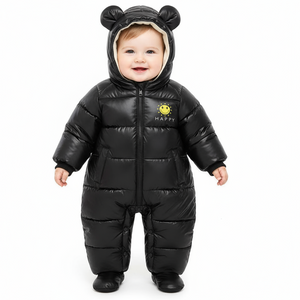 Baby wearing a black puffer snowsuit with bear ears on a white background