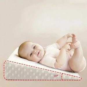 A baby lying on a white wedge-shaped anti-reflux pillow with a 10-degree incline, designed to provide comfort and reduce reflux.