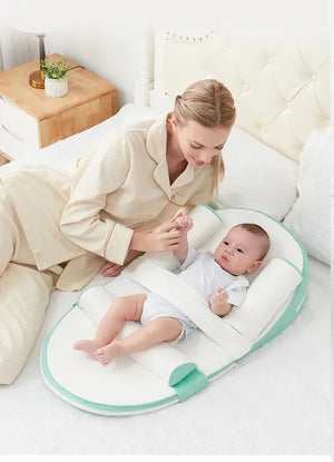 mom and baby resting on a baby lounger bed