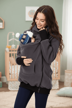 Woman holding a baby in a sling in a nursery setting