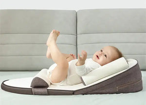 a baby is staying on a baby lounger bed