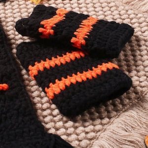 Black and orange striped gloves on a textured surface