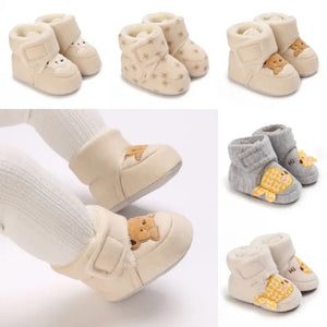 Baby booties with teddy bear design on a white background