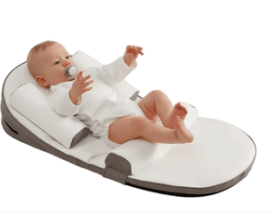 a baby is laying on a baby lounger bed very happy