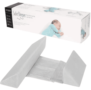 A newborn baby lying on a green Anti-Roll Side Sleeper Pillow Wedge with a removable cover.