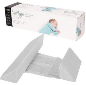 A newborn baby lying on a green Anti-Roll Side Sleeper Pillow Wedge with a removable cover.