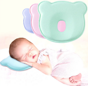 A baby lying on a green donut-shaped baby head rest pillow designed for anti-flat head support.