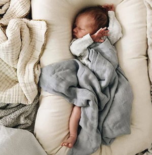 a baby sleeping in a baby lounger nest