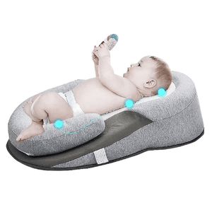 Baby lying on a gray and black baby lounger with a toy.
