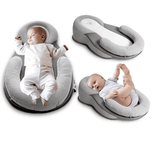 Baby lying on a gray baby lounger with another baby sitting on a separate gray cushion.