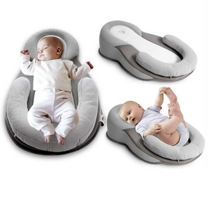 Baby lying on a gray baby lounger with another baby sitting on a separate gray cushion.