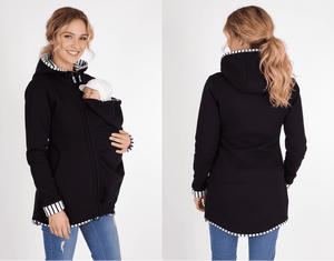 Woman wearing a black hoodie with a baby carrier feature, shown from front and back views.