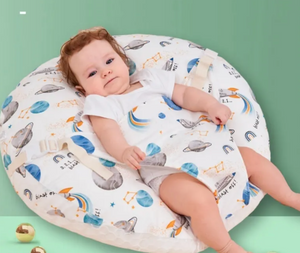 Baby lying on a soft, patterned cushion against a green background