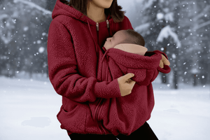 Person wearing a red fleece jacket holding a baby in a snowy setting with a flame icon indicating warmth.