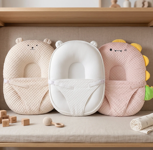 Three baby head support pillows with animal designs on a wooden shelf.