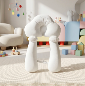 White cloud-shaped chair in a playroom with toys and a colorful mobile.