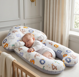 Baby sleeping on a colorful U-shaped pillow in a nursery setting