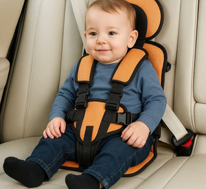 Child in an orange and black car seat inside a vehicle.