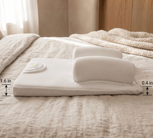 A white ergonomic mattress topper with a built-in headrest and a small built-in remote, displayed on a beige textured bed. Dimension overlays indicate a height of 1.