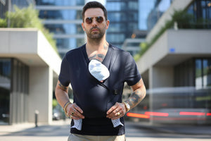 Man wearing a black leather vest over a graphic t-shirt with a white design.