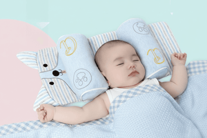 Baby sleeping with a soft toy and pillow on a light blue background