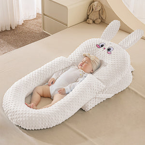 A baby lying in a white U-shaped inclined sleeper pillow with a soft texture, designed for anti-reflux and secure sleeping.